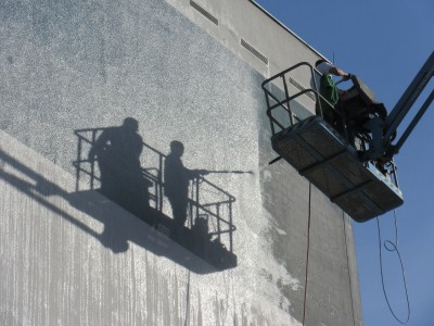hommes entrain de nettoyer une façade avec un nettoyeur haute pression